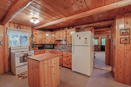 eine Küche mit einem weißen Kühlschrank und Holzschränken in der Unterkunft Grandma's Cabin Yellowstone Vacation Home in Island Park