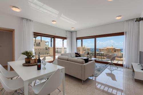 a living room with a couch and a table and chairs at Aphrodite Hills Rentals - Premium Serviced Apartments in Kouklia