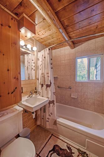 a bathroom with a sink and a tub and a toilet at Grandma's Cabin Yellowstone Vacation Home in Island Park