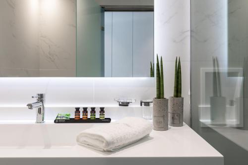 bagno con lavandino, specchio e asciugamano di Messinian Icon Hotel & Suites a Kalamáta