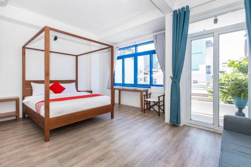 GIS Hotel Nha Trang في نها ترانغ: غرفة نوم مع سرير المظلة ومكتب