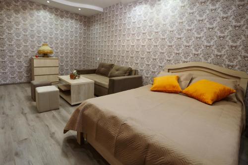 a bedroom with a bed and a couch and a chair at N&N House in Tbilisi City