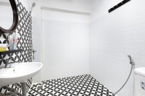 bagno con lavandino bianco e pavimento piastrellato bianco e nero. di GIS Hotel Nha Trang & Motorbike Rental a Nha Trang