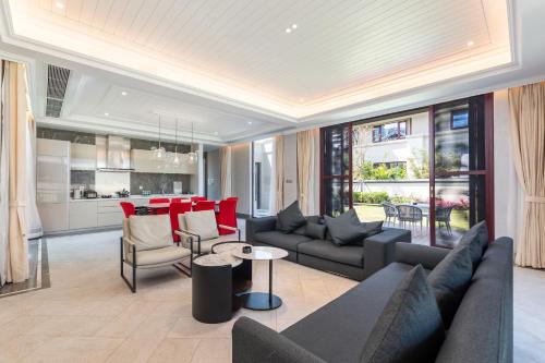 a living room with couches and a table and a kitchen at HaitangBay Loosen Coast Resort Villas in Sanya