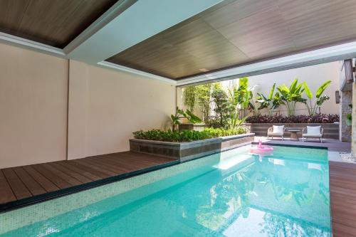 an indoor swimming pool with a patio and a house at HaitangBay Loosen Coast Resort Villas in Sanya