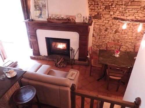 een woonkamer met een bank en een open haard bij Domaine du Bouysset in Saint-Martin-le-Redon