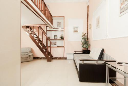 a living room with a staircase and a couch at Rent Apartments Grecheskaya 50 in Odesa