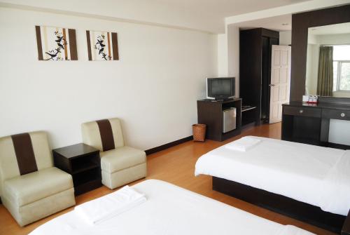 a hotel room with two beds and a television at Roma Hotel in Khon Kaen