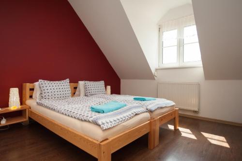 a bedroom with a bed with blue sheets and a window at Ubytování Merlot in Mikulov