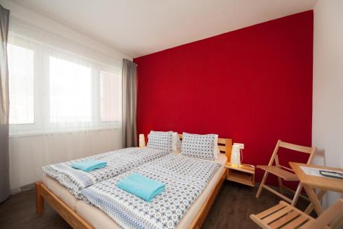 a bedroom with a bed with a red wall at Ubytování Merlot in Mikulov