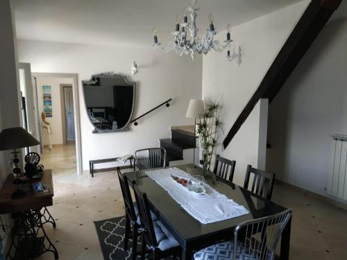 een eetkamer met een tafel met stoelen en een kroonluchter bij Villa Venino in Moneglia