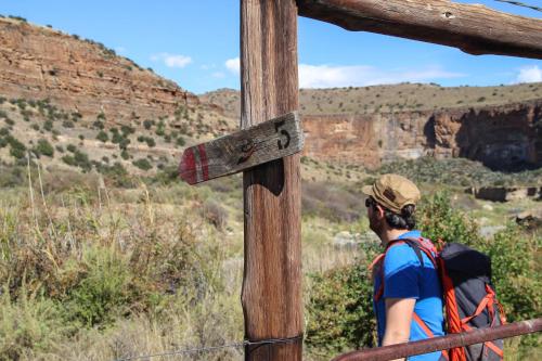 a man with a backpack looking out over the canyon at Ganora Guest Farm, Camping and Excursions in Nieu-Bethesda