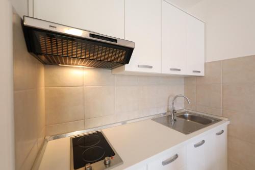 a kitchen with a sink and a microwave at Villa Pino with Pool, Sauna & Jacuzzi in Petrcane