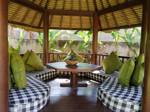 a porch with couches and a table in a room at Villa Kelapa Candidasa in Candidasa