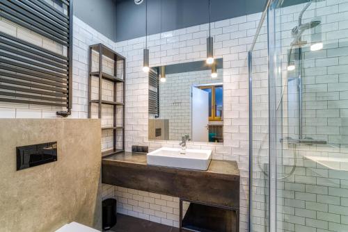 bagno con lavandino e specchio di Aparthotel Delta Top a Cracovia