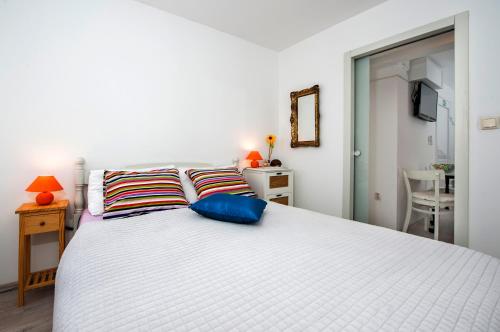 sypialnia z białym łóżkiem i dwiema poduszkami w obiekcie Apartman Delfin w Rovinj