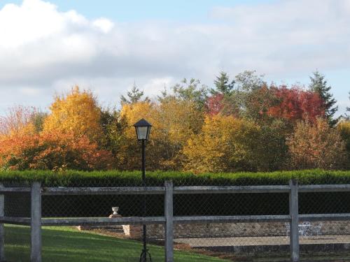 a park with a fence and a street light and trees at Chambres d'hôtes La Colinière in Batilly-en-Puisaye