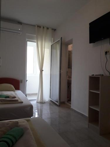 a bedroom with a bed and a sliding glass door at Apartmani Andrea-jaz in Budva