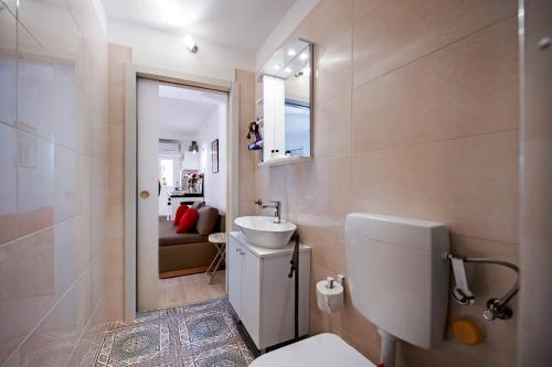 łazienka z toaletą i umywalką w obiekcie Apartman Delfin w Rovinj