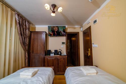 a bedroom with two beds and a tv on the wall at Villa Etiquette in Deva