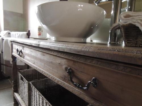 lavabo en la parte superior de un tocador de madera en el baño en Chambres d'hôtes La Colinière, en Batilly-en-Puisaye