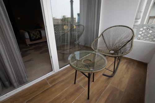 a couple of chairs and a glass table in a room at Clarks Inn Suites Raipur in Raipur