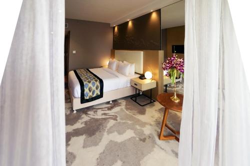 a bedroom with a bed and a table with flowers at Clarks Inn Suites Raipur in Raipur