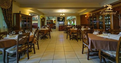 a restaurant with tables and chairs in a room at Villa Etiquette in Deva