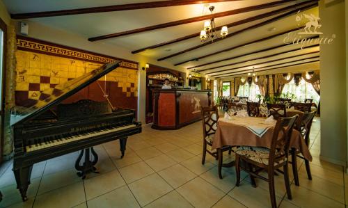 comedor con piano y mesa con sillas en Villa Etiquette en Deva