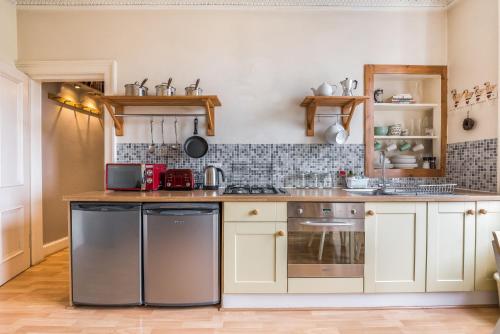a kitchen with white cabinets and a stove top oven at Spacious & Unique city central 1 bed with WiFi in Edinburgh
