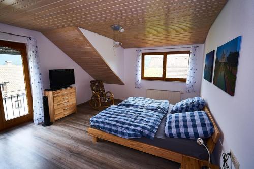 1 dormitorio con 1 cama y TV en una habitación en Ferienwohnung Sulzberg, en Alpirsbach