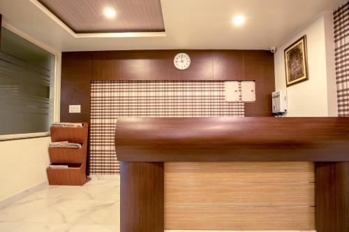 a lobby with a reception desk with a clock on the wall at Elite Suites MINT Gomti Nagar in Lucknow
