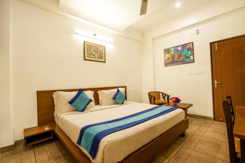 Elite Suites MINT Gomti Nagar في لاكناو: غرفة نوم بسرير كبير في غرفة