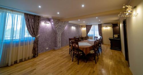 a dining room with a table and chairs in a room at Villa Etiquette in Deva