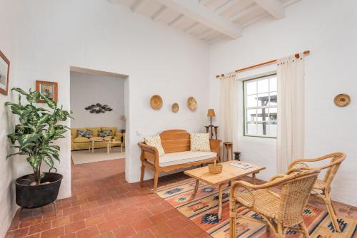 a living room with a couch and a table at Finca Binicalaf Vell in Cala en Porter