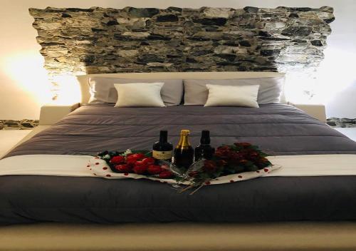 łóżko z 2 butelkami wina i kwiatami w obiekcie La Casetta di Angela w mieście San Leonardo