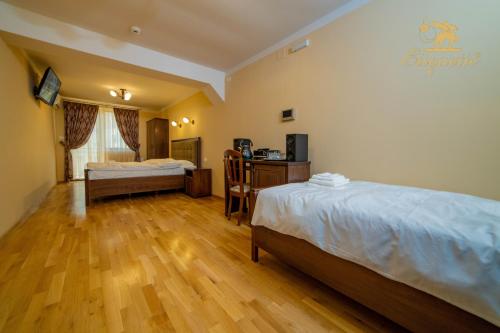 um quarto de hotel com duas camas e uma mesa e uma secretária em Villa Etiquette em Deva
