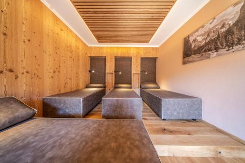a row of metal benches in a room with wooden walls at Dolomitenhotel Weisslahnbad in Tires