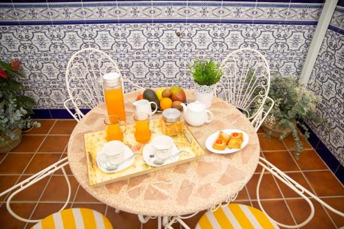 Una mesa con una bandeja de fruta y jugo de naranja. en Casa La Fuentecilla, en Consuegra