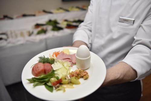 een chef-kok met een bord eten op een tafel bij FOUR SEVEN HOTEL in Istanbul