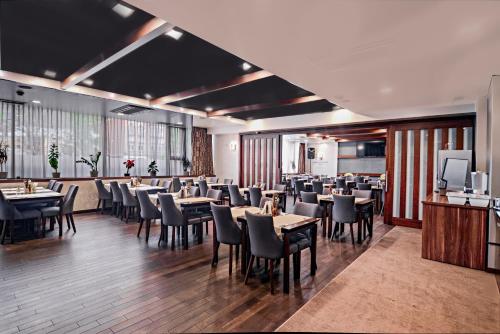 a restaurant with tables and chairs in a room at Hotel President Sarajevo in Sarajevo