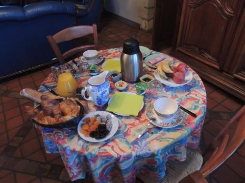 a table with a breakfast of food and fruit on it at Chambres d'hôtes La Colinière in Batilly-en-Puisaye