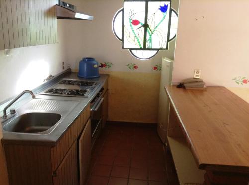 a kitchen with a sink and a stove and a window at Villas de la Montaña in Taxco de Alarcón