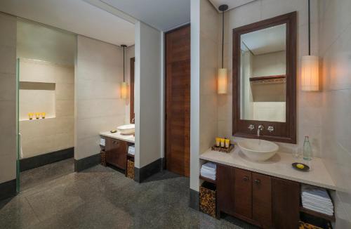 een badkamer met een wastafel en een spiegel bij The Chedi Muscat in Muscat