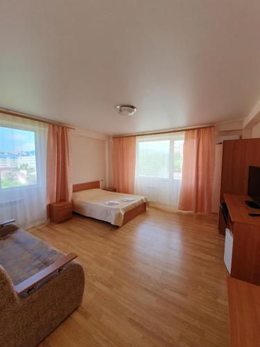 een grote kamer met een bed en 2 ramen bij Guest House Na Mamayke + in Sotsji