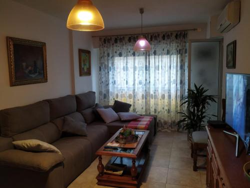 a living room with a couch and a table at Habitaciones privadas Alicante centro in Alicante