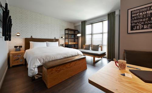 a hotel room with a bed and a desk and a couch at Just Sleep - Sanchong in Taipei