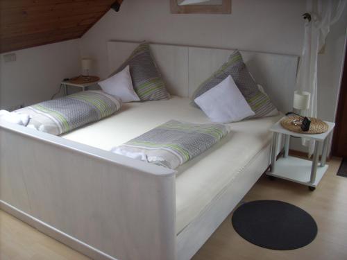 biała kanapa z poduszkami w pokoju w obiekcie Ferienwohnung Lahntal/Taunus w mieście Hochelheim