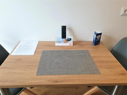 a wooden table with a remote control on it at easy sleep Apartmenthotel in Landshut