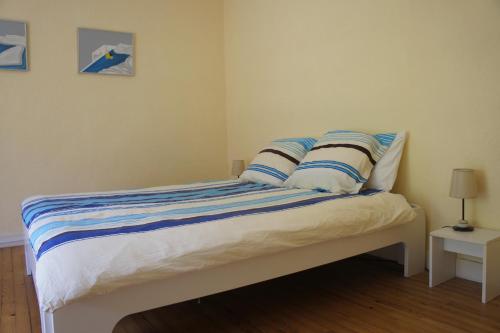 - une chambre avec un lit doté d'oreillers bleus et blancs dans l'établissement DOMAINE DU MURIER, à Die